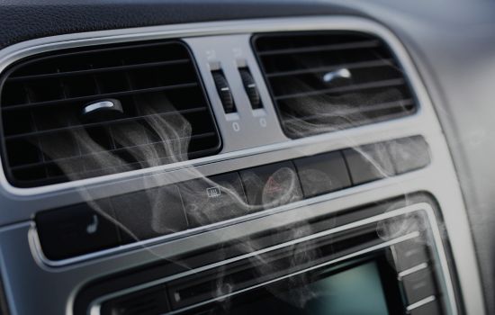 Girl with a broken AC unit in her car with a towel on her head.